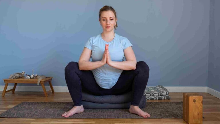 Malasana Prenatal Yoga – Supported Squat Pose for Expecting Moms Pregnant woman practicing supported Malasana squat prenatal yoga pose to open hips and prepare pelvic muscles