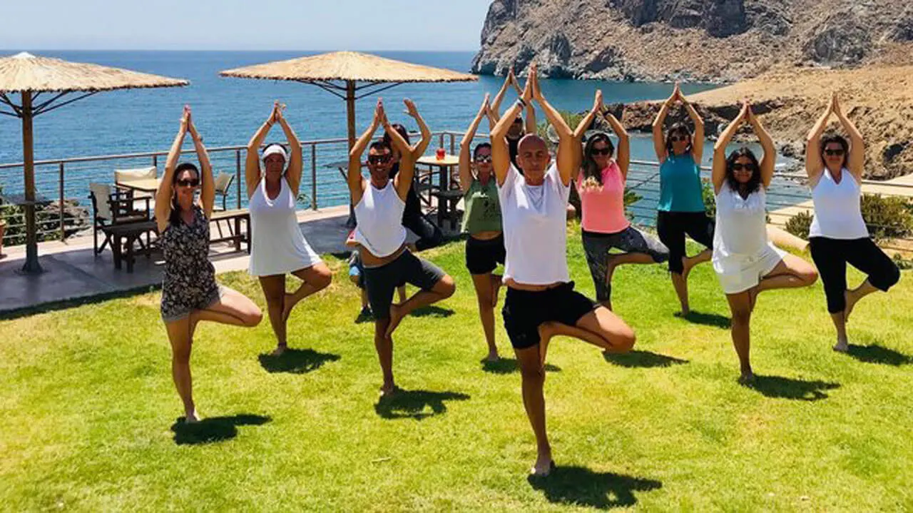 Yoga teacher training in Greece by the beach with students practicing yoga