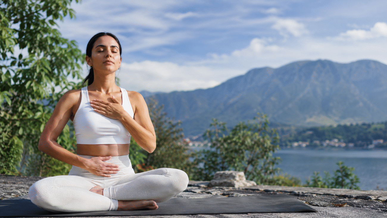 Woman practicing pranayama for anxiety outdoors with mindful deep breathing to calm the nervous system in a peaceful natural setting.Woman practicing pranayama for anxiety outdoors with mindful deep breathing to calm the nervous system in a peaceful natural setting.
